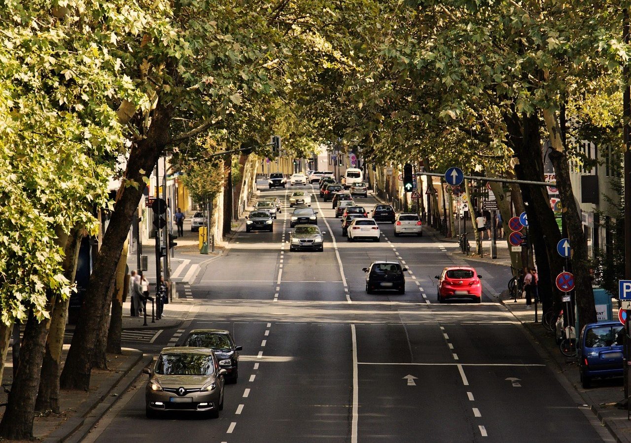 Rue de quartier avec voitures garées, trajets de proximité