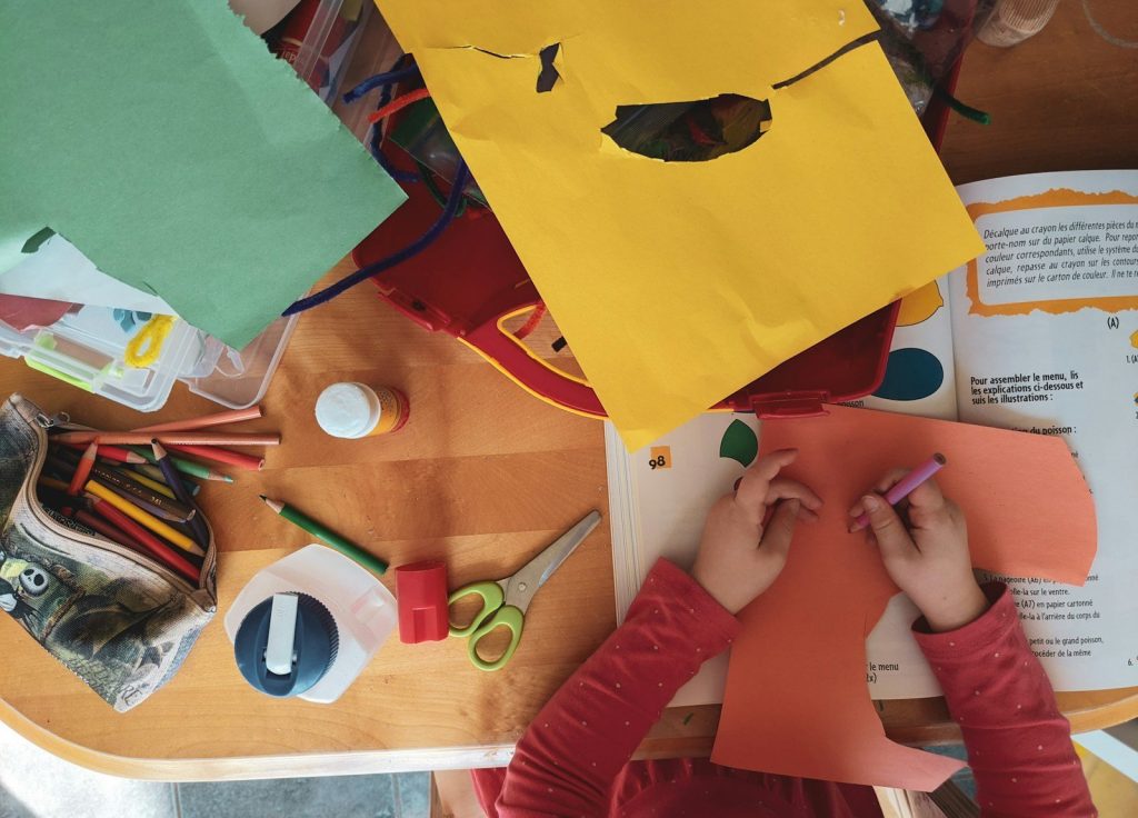 Enfants fabriquant des masques en papier avec crayons et colle