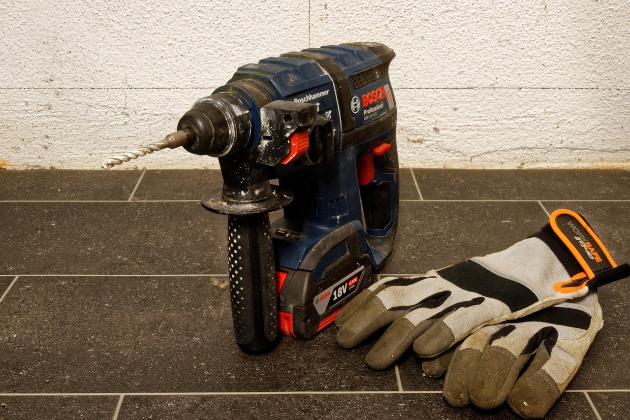 Perceuse-visseuse sans fil posée avec des gants de travail