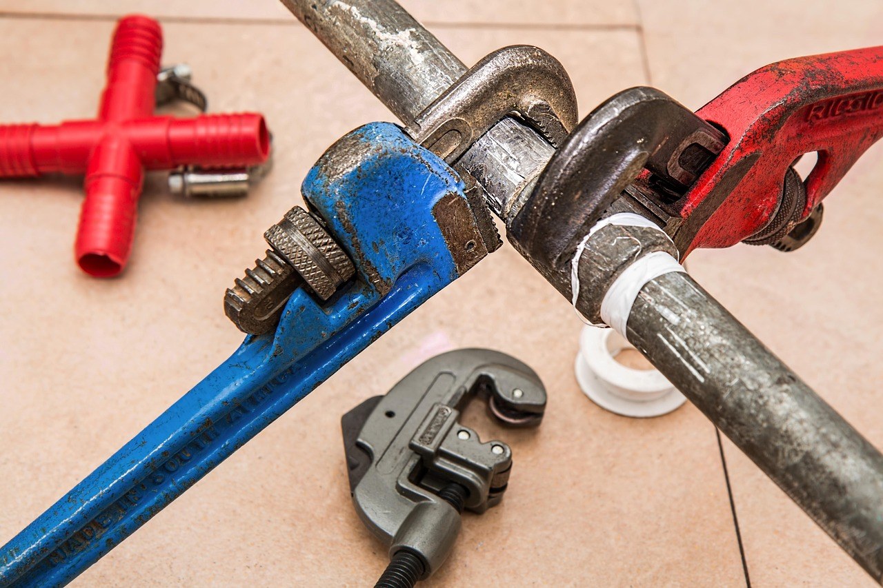 Clés de plomberie rouge et bleue sur des tuyaux, outillage magasin de bricolage