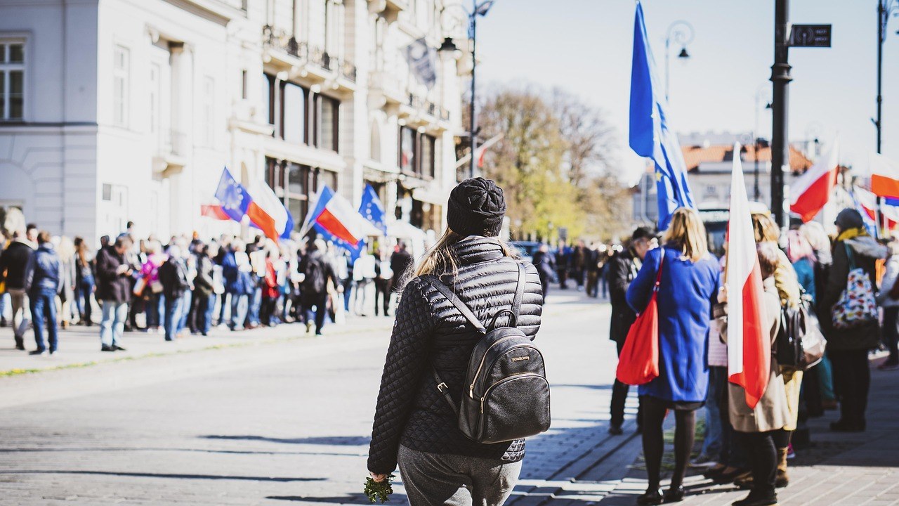 Manifestants dans une rue européenne avec drapeaux, mobilisation sociale