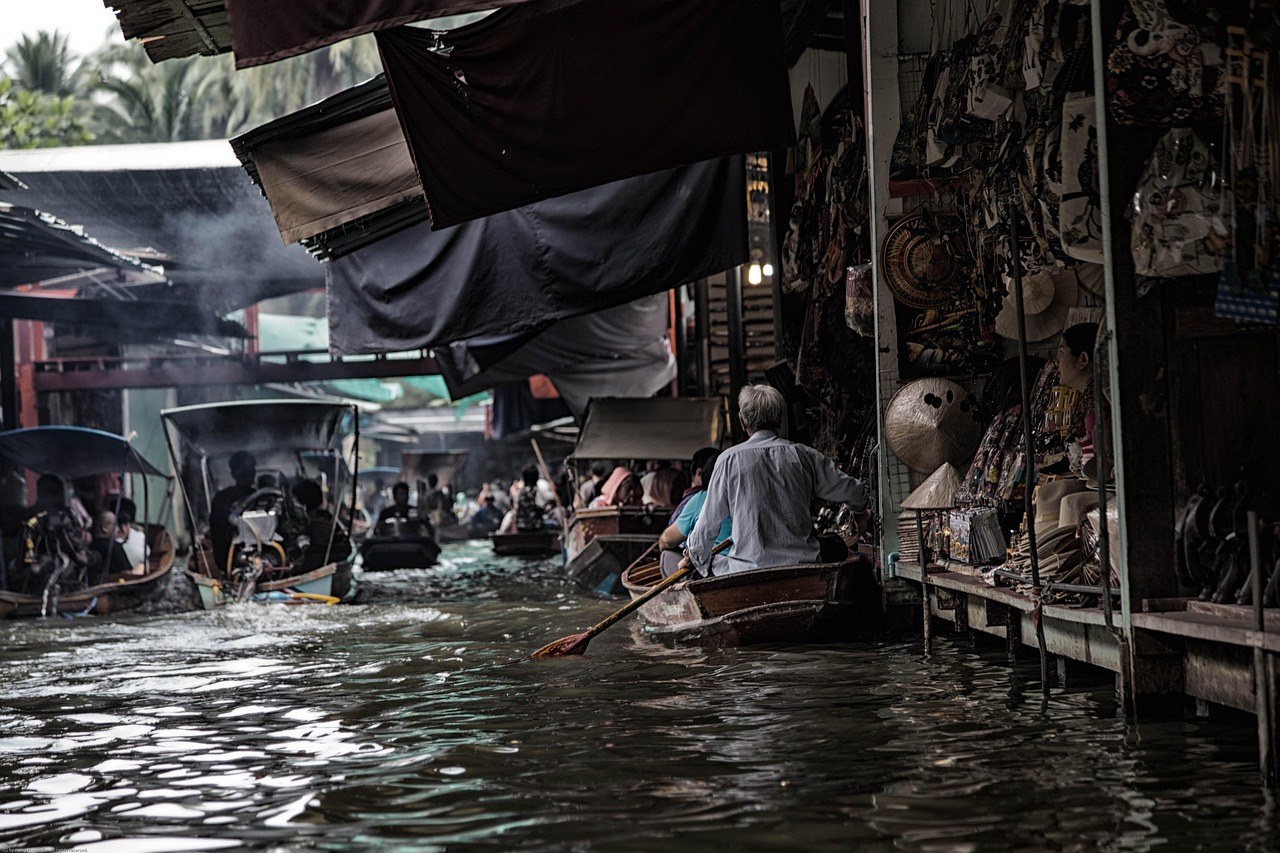 Marché flottant traversé en barque lors d'une inondation urbaine en Asie