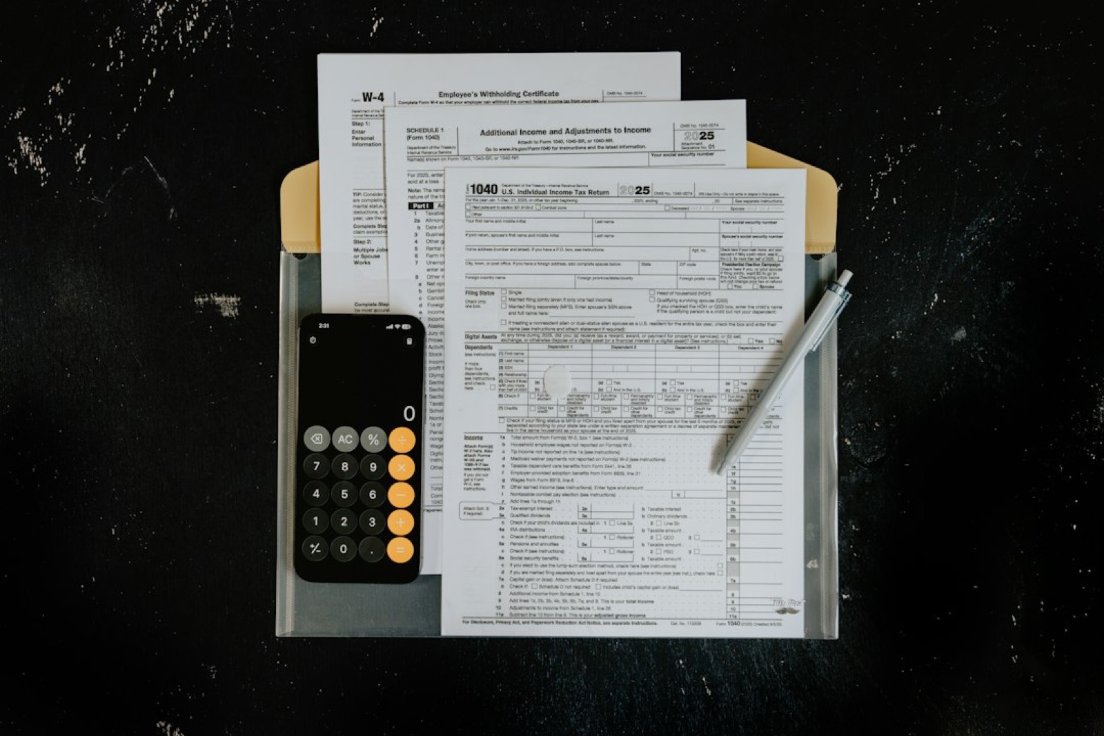 Calculatrice, factures et papiers de comptabilité posés sur un bureau